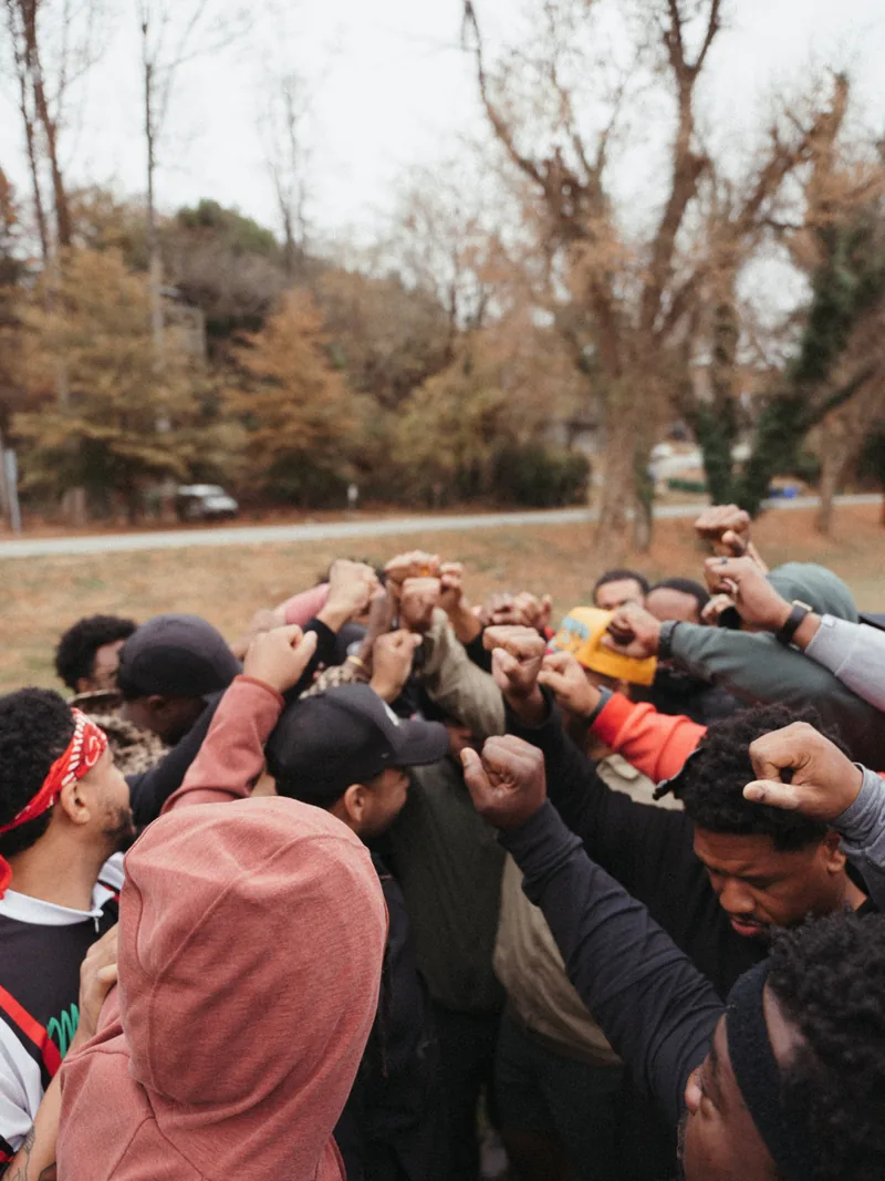 The men stacking hands in a tight huddle, seen from above