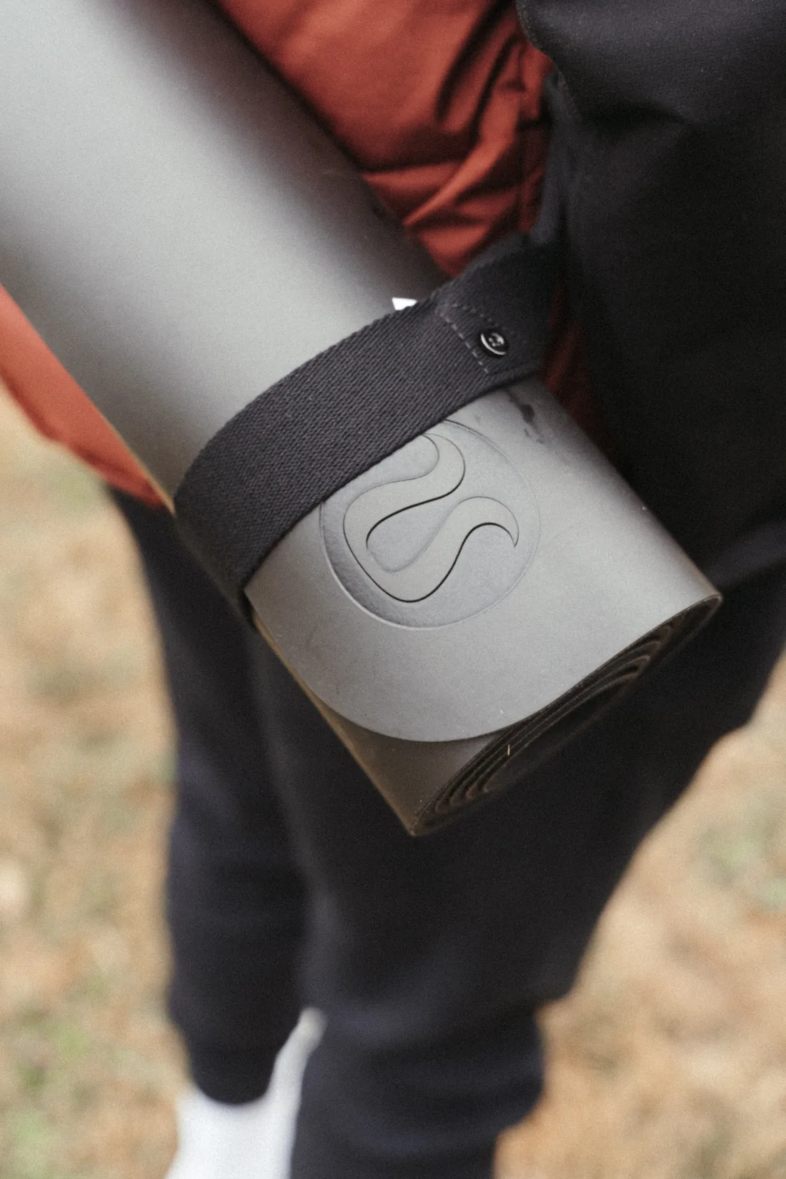 A rolled lululemon yoga mat carried by its strap at a Healing retreat